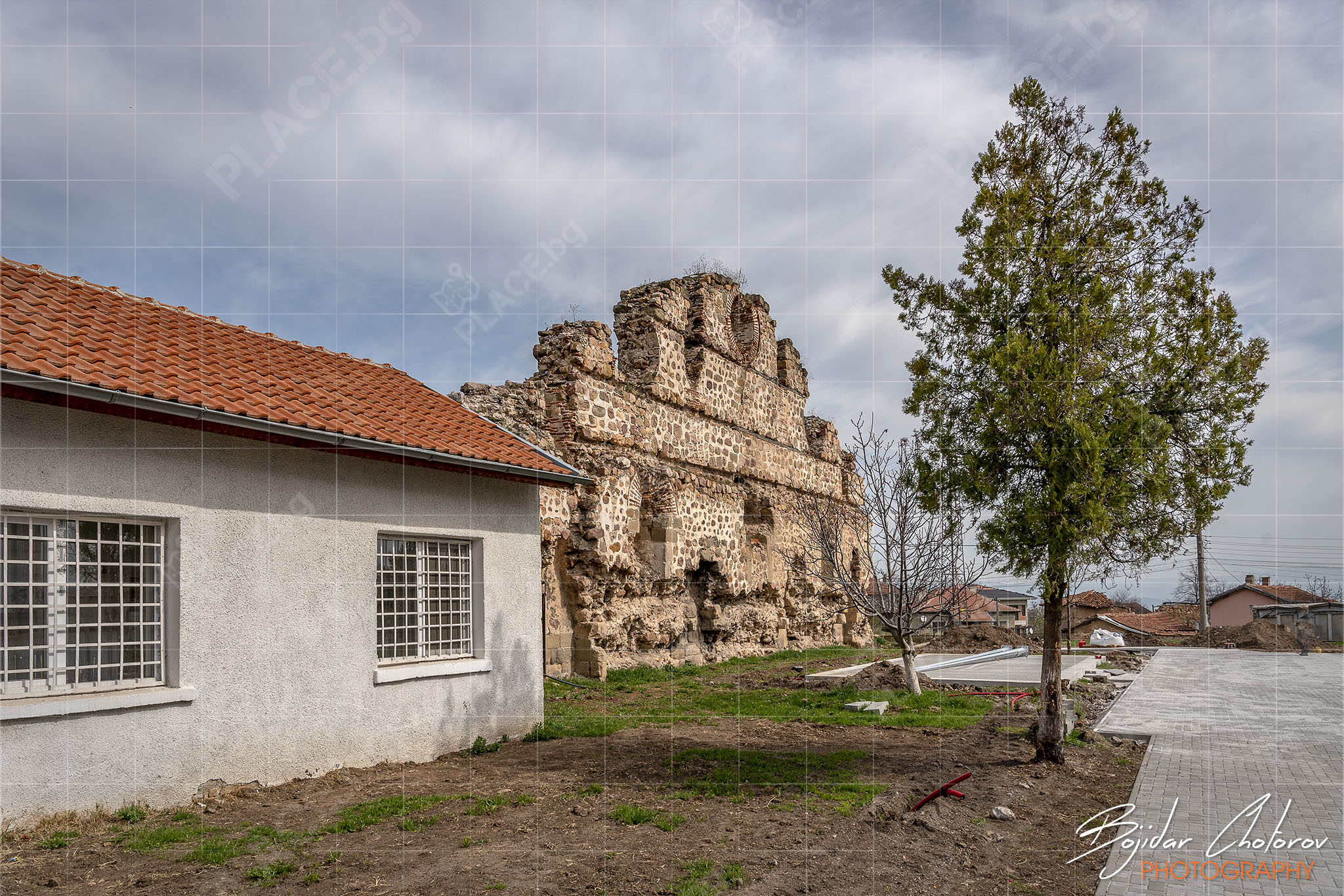 Останките от стената на кервансарая с една от училищните сгради (BCH_5186)